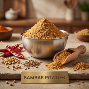 Bowl of sambar powder with a metallic tag and whole spices
